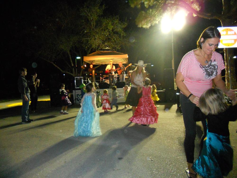 Children and adults dance in front of stage